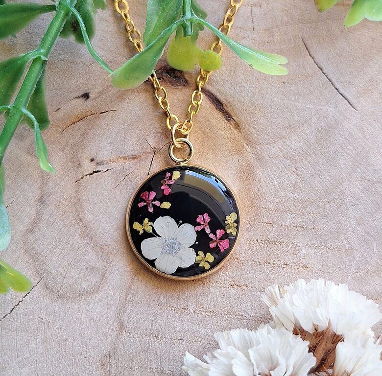 Wisiorek z żywicy - suszone kwiaty na czarnym tle